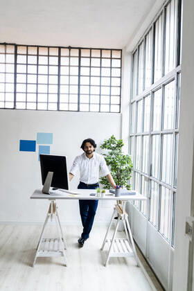 Young businessman standing by desk in office model released Symbolfoto property released GIOF12869