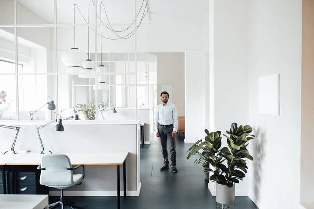 Male entrepreneur staring while standing in office model released Symbolfoto property released GUSF06026