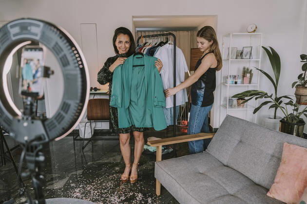 IMAGO Creative: Digitale Welt, Social Commerce Female fashion influencers showing dresses while filming at home model released Symbolfoto property released MFF08094