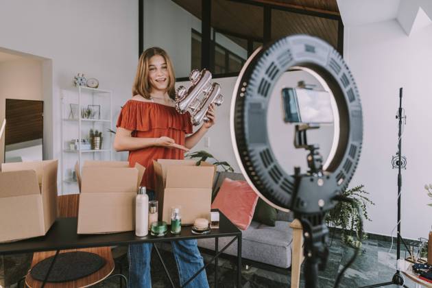 Teenage girl holding hashtag sign and filming at home model released Symbolfoto property released MFF08168