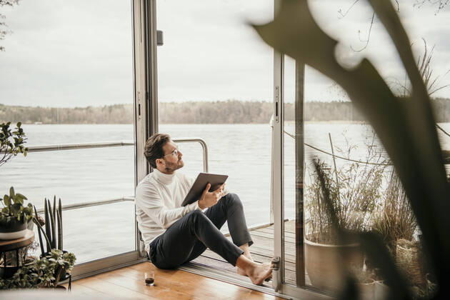 Male professional looking away while sitting with digital tablet on houseboat model released Symbolfoto property released MJRF00508