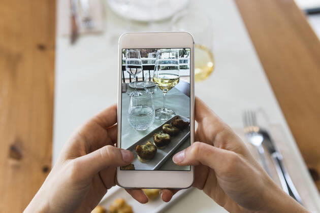 IMAGO Creative, Food, Tapas Young woman photographing food through smart phone at restaurant model released Symbolfoto property released PNAF01790