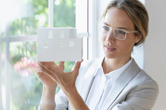IMAGO Creative: Internationaler Frauenmonat, Geschlechterrollen aufbrechen IMAGO Creative: Klimawandel - Zukunft und Innovation Female professional checking architectural model by window in office model released Symbolfoto property released SBOF03926