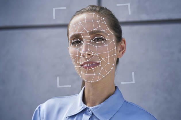 Businesswoman with facial recognition biometrics in front of wall model released Symbolfoto property released ABIF01401