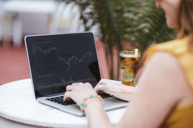 IMAGO Creative: 2022 Aussichten IMAGO Creative: 2021 Trends Woman trading on stock market through laptop at bar model released Symbolfoto property released LJF02198