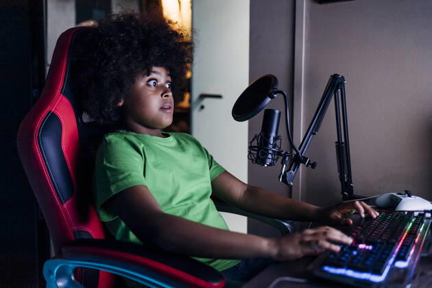 Shocked boy playing video game on computer at home model released Symbolfoto property released MEUF03411