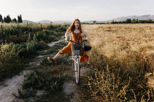 Carefree woman riding bicycle in agricultural field model released Symbolfoto TCEF01965