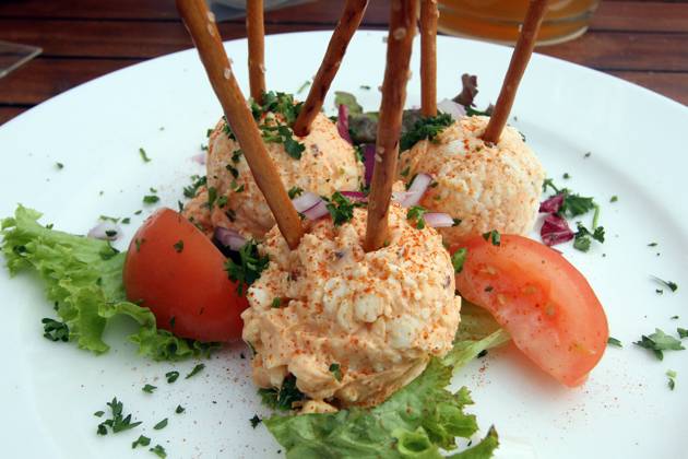 Bavarian speciality Obazda with salt sticks stands on a table of a Bavarian beer garden in Wiesbaden, Hesse, Germany