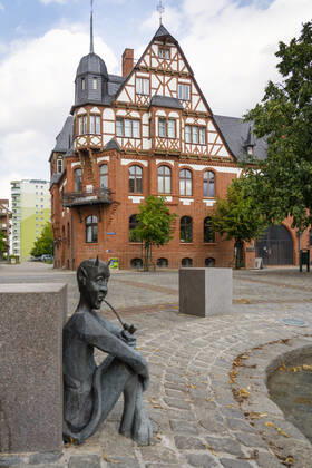 The tobacco fountain by the artist Jan Witte Kropius on the Vierradener Platz in Schwedt Oder district of Uckermark The fountain shows a worker hanging tobacco to dry A little devil leans against a seat and smokes a pipe Photo Volker Hohlfeld The tobacco fountain in Schwedt Oder