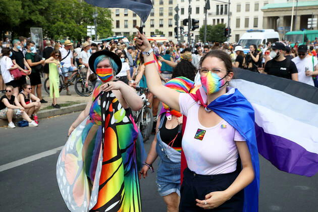 Berliner CHRISTOPHER STREET DAY 2021 - CSD - Am 24. Juli 2021 zieht der CSD in Berlin unter dem Motto SAVE OUR COMMUNITY SAVE YOUR PRIDE zum 43. Mal durch die Hauptstadt. Demoteilnehmer tragen Mundschutzmasken in Regenbogenfarben. Person rechts im Bild trägt Pride Flag für asexuelle Menschen. Die bunte CSD-Parade startete in diesem Jahr als Demonstration an der Leipziger Straße, führte über den Potsdamer Platz, vorbei am Denkmal für die im Nationalsozialismus verfolgten Homosexuellen zum Brandenburger Tor und über die Siegessäule zur Urania. Aufgrund der Corona-Pandemie fand die Demonstration ausschließlich unter Einhaltung der vom Berliner Senat erlassenen Vorgaben statt. Die in den Vorjahren übliche Abschlusskundgebung muss