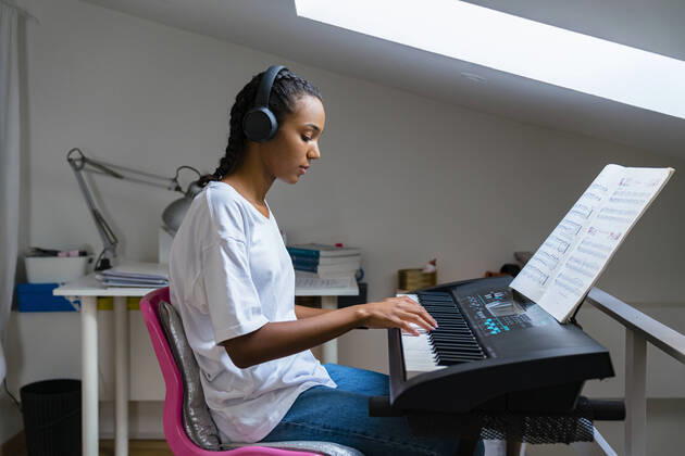 IMAGO Creative: Bildung, Musikerziehung Teenage girl playing piano while sitting at home model released Symbolfoto property released MGIF01029