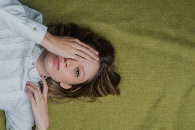 IMAGO Creative: Digitale Welt, Verzicht auf Technologie Top view of calm young long haired female with green eyes covering half of face with hand and looking at camera JoseDeJesusSaldana_GreenEyedWoman_24.jpg Copyright: xJosexDexJesusxSaldana?x Model Released