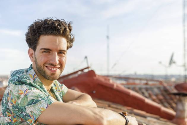 IMAGO Creative, Jahreszeit Sommer, Sommer in der Stadt Smiling young man on terrace during weekend model released Symbolfoto property released IFRF00991