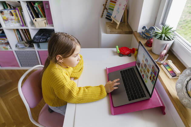 Girl using laptop on desk while learning at home model released Symbolfoto property released KMKF01720