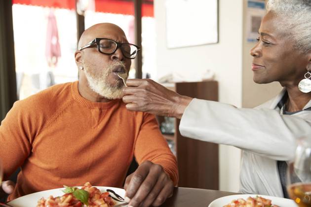 Woman feeding man with fork in restaurant model released Symbolfoto property released PMF02052