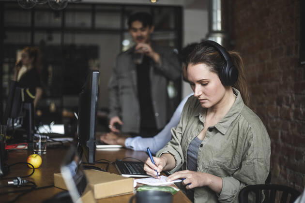 Businesswoman writing in note pad while working in office Sweden, Stockholm, model released, property released Copyright: xMaskotx , MA87932