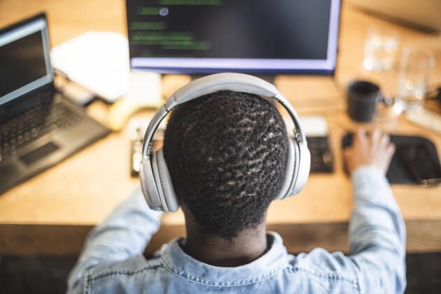 Rear view of male hacker working on computer at office Sweden, Stockholm, model released, property released Copyright: xMaskotx , MA87959