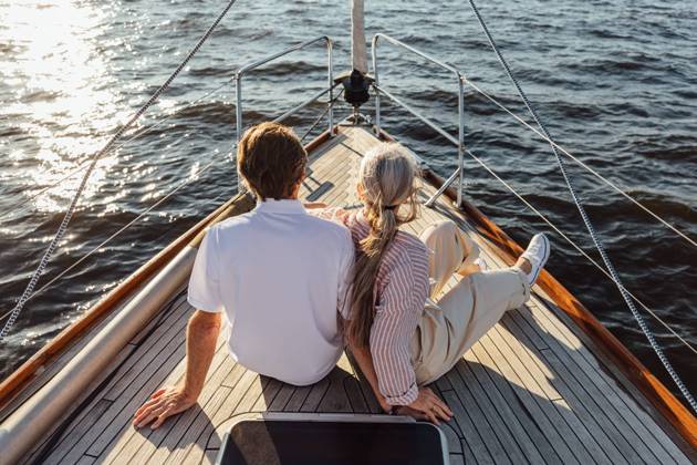 Rearview of two mature people sitting on a yacht bow. Loving senior couple enjoying a boat trip. Rearview of two mature people sitting on a yacht bow. Loving senior couple enjoying a boat trip. Copyright: xxArtemxVarnitsinx