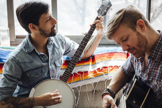 IMAGO Creative: Bildung, Musikerziehung Male couple at home, play guitar and banjo, 17.06.2015, Copyright: xAshleyxCorbin-Teichx, model released, wearing,learning,holding,playing,looking down,at home,concentration,focus concept,creativity,fun,inspiration,quality time,togetherness,friendship,happiness,love,relaxation,sofa,banjo,adult,mid adult,30 to 34 years,young adult,25 to 29 years,caucasian ethnicity,hispanic ethnicity,multi-ethnic group,male,man,mid adult man,only men,young man,homosexual couple,two people,gay man,house interior,indoors,living room,day,casual clothing,entertainment,sitting,smiling,music,leisure,display,mixed age group,playing guitar,comfort,only male,musical instrument string,June 2015 Release,Playing,Sitting,Thinking,Concentration,Learning,Holding,Looking Ref:IS09AS0NF