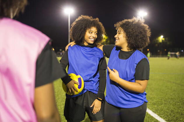 IMAGO Creative: Internationaler Frauenmonat, Mädchen im Sport Female football players jubilant, Hackney, East London, UK, 12.10.2017, Copyright: xBenxPipexPhotographyx, model released, wearing,practising,celebrating,close-up,differential focus,waist up,girl power,connections,real people,achievement,athleticism,bonding,competition,fitness,teamwork,triumph,victory,winning,friendship,happiness,joy,ball,soccer ball,floodlight,20 to 24 years,16 to 17 years,caucasian ethnicity,mixed race ethnicity,female,girl,teenage girl,woman,young woman,three people,soccer player,united kingdom,london,outdoors,night,soccer pitch,soccer uniform,communication,face to face,hand on shoulder,laughing,smiling,afro,leisure,sport,soccer,active lifestyle,empowered,african ethnicity,relationship,only female,Star Images,hackney, Ref:IS09B8U0R