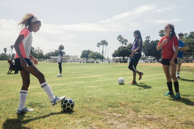 IMAGO Creative, Jahreszeit Sommer, Sommerferien IMAGO Creative: Internationaler Frauenmonat, Mädchen im Sport Schoolgirls practicing face to face with soccer ball on school sports field, 12.12.2017, Copyright: xAshleyxCorbin-Teichx, model released, wearing,learning,teaching,kicking,practising,recreation,working,full length,side view,adolescence,childhood,concentration,responsibility,cooperation,encouragement,fitness,innocence,sharing,skill,teamwork,friendship,on the go,soccer ball,30 to 34 years,child,10 to 11 years,teenager,13 to 15 years,16 to 17 years,caucasian ethnicity,female,girl,teenage girl,male,man,mid adult man,six people,schoolgirl,teacher,soccer player,school,united states of america,california,outdoors,summer,day,playing field,sportswear,education,energy,face to face,sunlight,sport,soccer,active lifestyle,long beach,physical educati Ref:IS09B9GP2