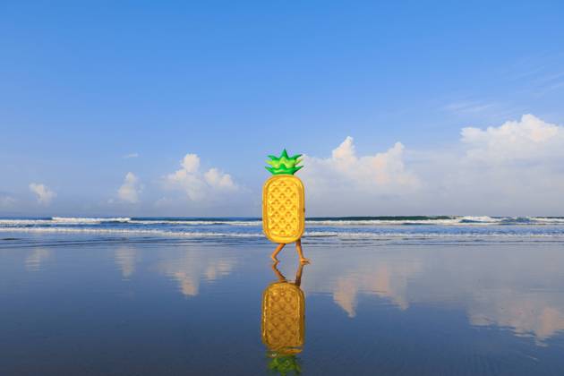 Woman with pineapple float walking at beach model released Symbolfoto EAF00114