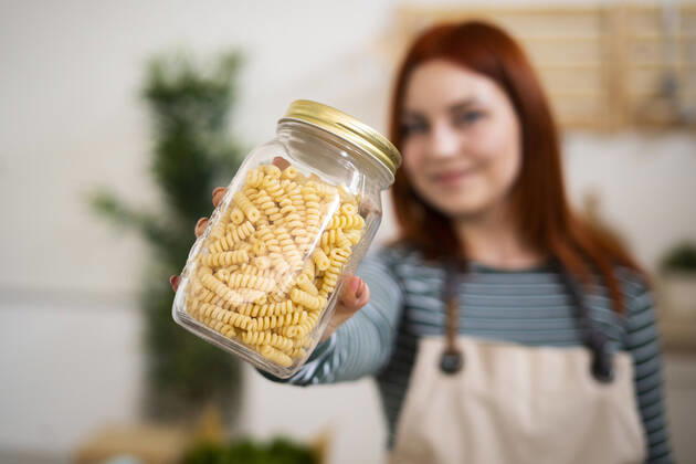 Woman holding pasta jar in kitchen model released Symbolfoto property released GIOF13223