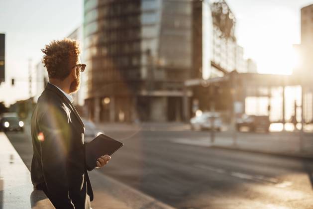 IMAGO Creative, Jahreszeit Sommer, Sommer in der Stadt Businessman holding digital tablet on footpath during summer model released Symbolfoto GUSF06347