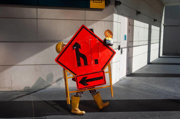 23 09 2021, Singapore, Republic of Singapore, Asia A worker in the city center carries a device with street signs and warning lights during the ongoing Corona crisis.
