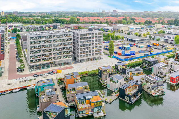IMAGO Creative, Jahreszeit Sommer, Sommer in der Stadt Drone view of contemporary building facades against pier and houseboats on rippled river in Amsterdam Netherlands CasaMedia_Fonteinkruidstraat56_1.jpg Copyright: xCasaxMediax Model Released
