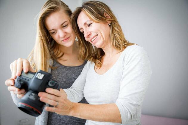  Mother and daughter taking photos and checking them on a modern digital DSLR camera model released, Symbolfoto, 13.10.2020, Copyright: xLightpoetx Panthermedia26943734