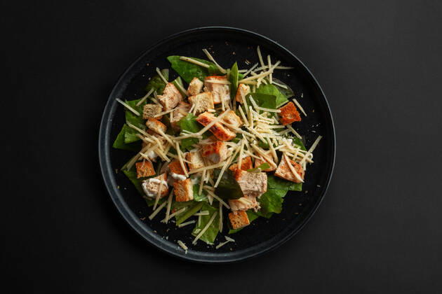 Caesar salad top view Caesar salad top view on black table over black table background Copyright: xMikhailovaxLiubovx 36570292