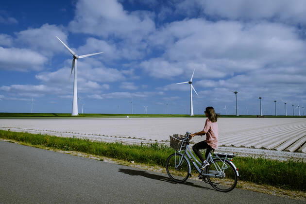 IMAGO Creative: Nächste Generation, Sozial- und klimabewusst young woman electric green bike bicycle by windmill farm , windmills isolated on a beautiful bright day Netherlands Flevoland Noordoostpolder young woman electric green bike bicycle by windmill farm, windmills isolated on a beautiful bright day Netherlands Flevoland Noordoostpolder Holland Copyright: xFOKKExBAARSSENx 38159040