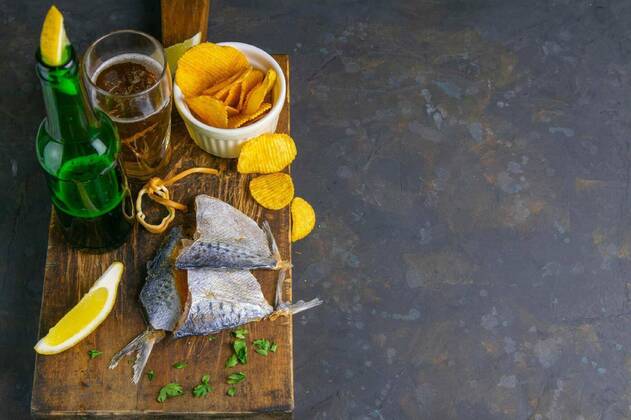 IMAGO Creative, Food, Karpfen-Saison Dried bream in form butterfly with beer, lemon and potato chips on dark wooden board. Snack on fish with beer. Top views with clear space, 14.10.2020, Copyright: xuspmenx Panthermedia28430681
