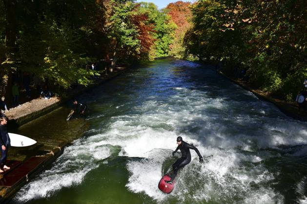 Autumn presents the English Garden in Munich on Wednesday 27 10 2021 The autumn has colored the trees, in glorious sunshine the park attracts many people A crowd puller is the standing wave in the Eisbach, a paradise for surfers in the middle of the city