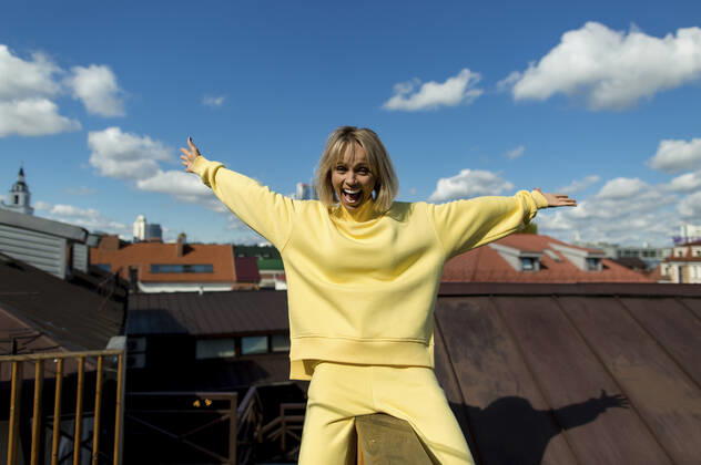 Cheerful woman with arms outstretched enjoying on rooftop model released, LLUF00162