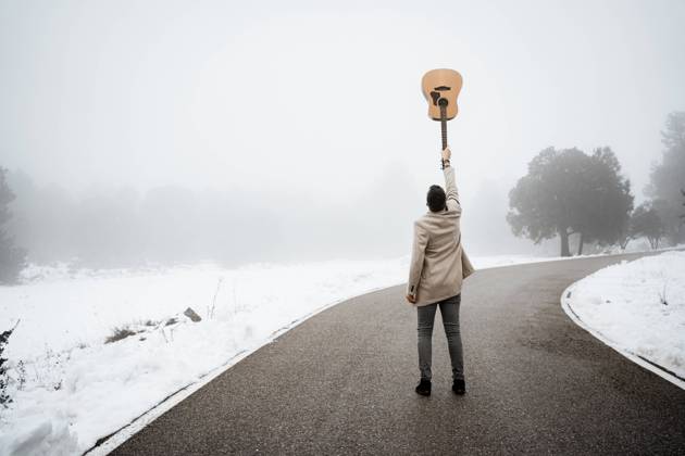Mature man with hand raised holding guitar on road model released, RCPF01341