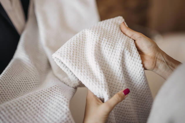 Woman checking fabric of clothes in shop model released, DAWF02267