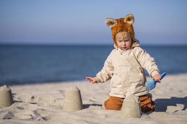 Girl making sandcastle at beach on sunny day model released, SSGF00209