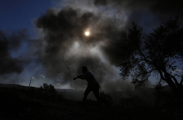 (211126) -- NABLUS, Nov. 26, 2021 -- A protester uses a slingshot to hurl a stone at Israeli soldiers in a protest against the expansion of Jewish settlements in the village of Beita, south of the West Bank city of Nablus, Nov. 26, 2021. (Photo by Ayman Nobani Xinhua) MIDEAST-NABLUS-CLASHES ChenxLin