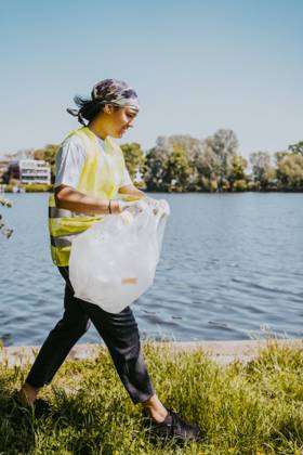 IMAGO Creative: Nächste Generation, Sozial- und klimabewusst Female environmentalist walking with plastic bag by lake Germany, Berlin, model released Copyright: xMaskotx , MA90305