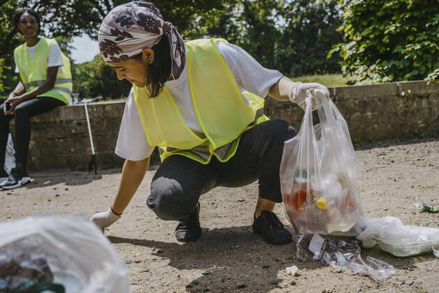 IMAGO Creative: Nächste Generation, Sozial- und klimabewusst Young female volunteer picking up plastic waste in park Germany, Berlin, model released Copyright: xMaskotx , MA90346