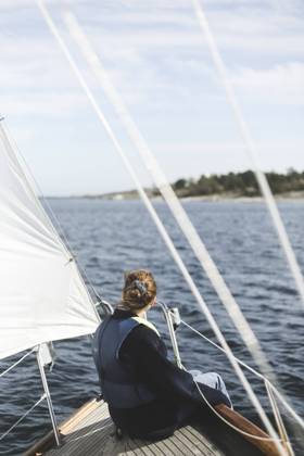 IMAGO Creative, Jahreszeit Sommer, Sommerferien Woman sitting in sailboat on sunny day Sweden, Stockholm archipelago, model released Copyright: xMaskotx , MA90630