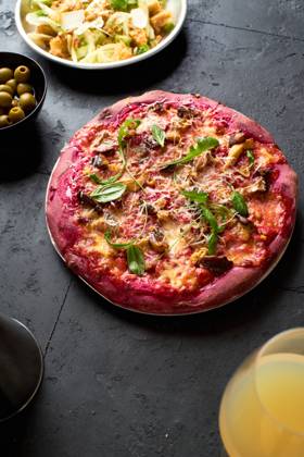 Purple colored rustic pizza with beetroot and vegetarian topping. Top view healthy food recipe AnastasiaNurullina_PurplePizza_10.jpg Copyright: xAnastasiaxNurullinax Model Released