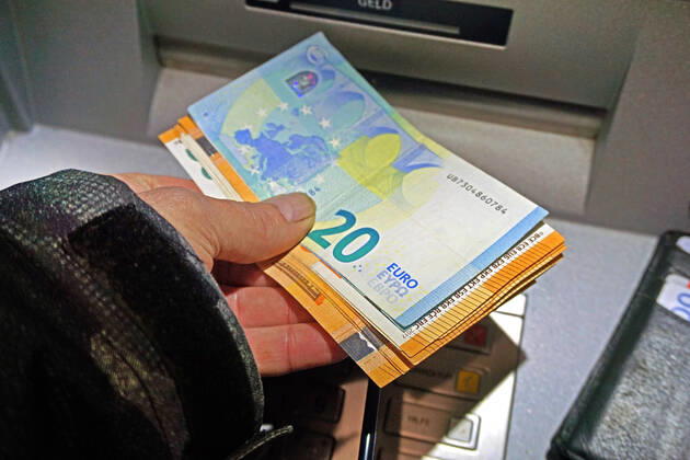Cash supply from an ATM A person withdraws cash from an ATM in 50 and 20 euro notes