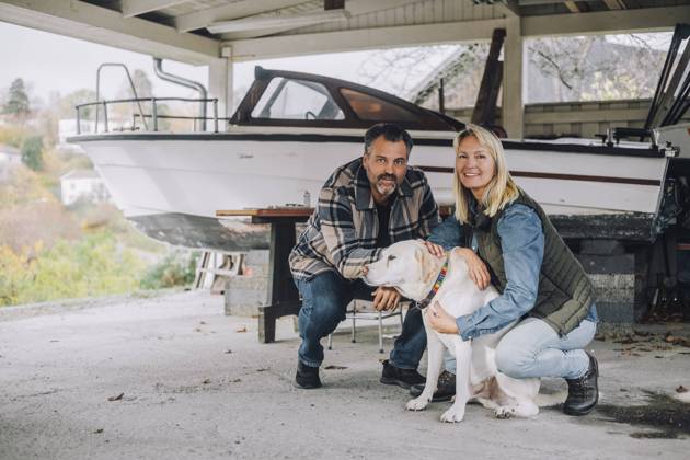 Portrait of smiling male and female friends with dog in garage Sweden, Stockholm, model released, property released Copyright: xMaskotx , MA91291