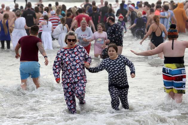 Over 350 New Year revellers, many in fancy dress, take part in the New Year Big Dip at East Wittering Beach in Chichester, West Sussex. More than double the previous record number of people took part, making the most of the warmest New YearÕs Day on record in the UK. JANUARY 1st 2022  MTXx2201