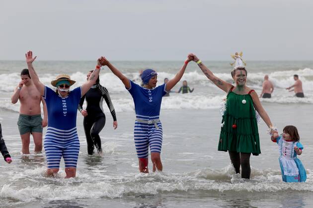 Over 350 New Year revellers, many in fancy dress, take part in the New Year Big Dip at East Wittering Beach in Chichester, West Sussex. More than double the previous record number of people took part, making the most of the warmest New YearÕs Day on record in the UK. JANUARY 1st 2022  MTXx2201