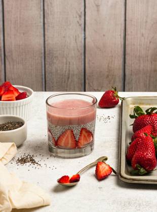 Tasty pudding with chia seeds and slices of fresh strawberries placed on table near ingredients for healthy breakfast NadiaSapollnik_ChiaFruit_1.jpg Copyright: xNadiaxSapollnikx Model Released