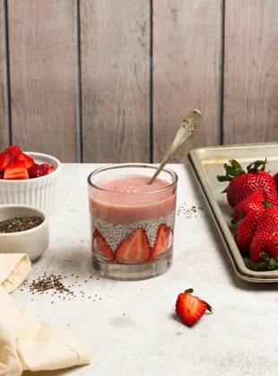 Tasty pudding with chia seeds and slices of fresh strawberries placed on table near ingredients for healthy breakfast NadiaSapollnik_ChiaFruit_2.jpg Copyright: xNadiaxSapollnikx Model Released